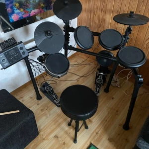 Elektroniskt trumset Gear4music DD450+ - Säljer ett komplett elektroniskt trumset från Gear4music, modell DD450+. Setet har flera trum- och cymbalpads, digital kontrollpanel och medföljande trumstol. Perfekt för dig som vill öva hemma utan att störa grannarna. Ett par hörlurar ingår i köpet. Köptes för några år sedan men har inte används mer är 10 gånger/ 2h!!!  Köptes för 5000kr! Pris kan diskuteras. Skickas ej / ligger i Skåne 