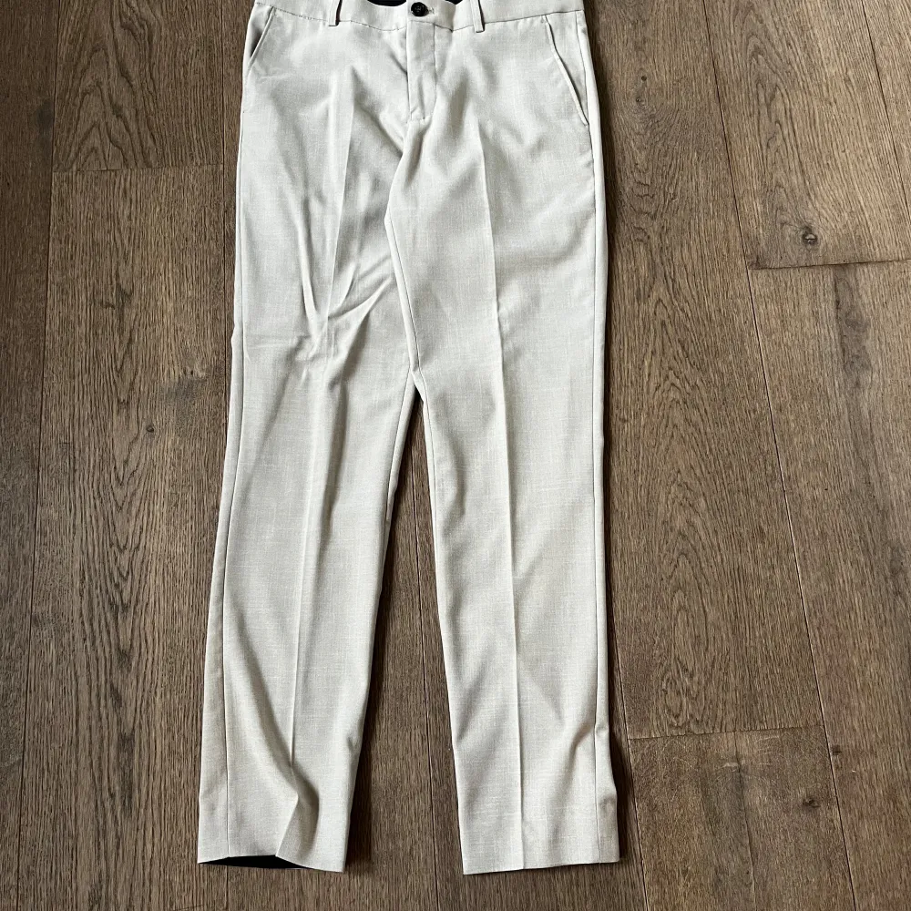 Snygg beige kostym från Lindbergh i storlek 48. Kavajen har två knappar framtill, klassiska slag och fickor med lock. Byxorna har raka ben och passpoalfickor bak. Perfekt för student eller sommarens tillställningar. Endast avnänd 1 gång, nyskick 10/10. Pris 999, kan dissekeras något vid snabb affär. Tveka inte på att skicka vid minsta fundering!. Puvut & Bleiserit.
