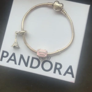 Pandora armband i silver  - Du kan köpa ba armbandet eller bara berlockerna skriv t mig så fixar ja de Nästan ett helt oanvänt Pandora armband Pandora armbandet är värt 1880 kr då kedjan kostar 800 original o berlockerna 540 styck de är en res väska som d rosa o ett Paris torn, pris kan diskuteras 