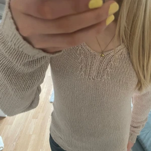 Beige/rosa stickad tröja från Gina Tricot - Säljer rosa/beige stickad tröja 💕 Tröjan har v-ringning och fina stickade detaljer upptill. Långärmad o perfekt för lager-på-lager under kyligare dagar 😍