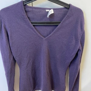 Lila v-ringad tröja från Vera - Säljer en lila långärmad tröja från Vera med v-ringning. Tröjan är tunnstickad och har en enkel, stilren design som passar perfekt till vardags. Supermjuk och skön att ha på sig!