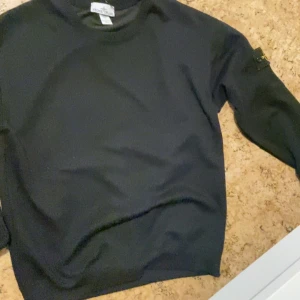 Svart sweatshirt från Stone Island - Säljer en svart sweatshirt från Stone Island i storlek L. Tröjan har rund halsringning och klassisk Stone Island-logga på ärmen. Perfekt för en stilren och avslappnad look. Den här helt ny och inte använd 