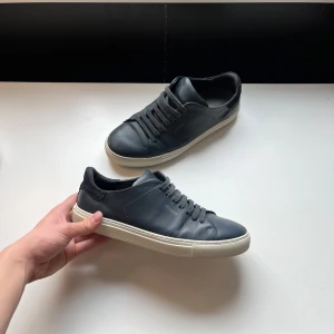 Marinblå sneakers från Axel Arigato - Snygga mörkblåa sneakers från Axel Arigato med vit platt sula och diskret logga. De är i perfekt skick. Fråga om du har frågor