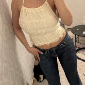  linnetopp med volanger - linnetopp med volangdetaljer och smala axelband. Toppen har knytning i ryggen och är ärmlös, perfekt för varma dagar. Materialet känns lätt och luftigt. 🤍Jag är 166 cm och bär storlek S/36 för referens!