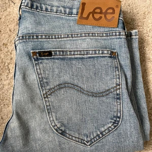 Ljusblå Lee Daren Zip Fly ljusblå jeans 29/34 - Säljer ett par klassiska ljusblå jeans från Lee, modell Daren Zip Fly. Jeansen har raka ben, normal passform och femficksdesign med dragkedjegylf. Perfekta för dig som gillar en tidlös denimlook.