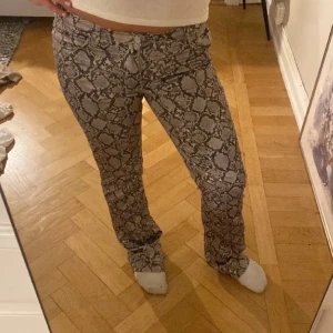 Mönstrade byxor - Säljer mina coola och snygga byxor med ormmönster från weekday💞midjemått:77,5 innerbenslängd:84,5
