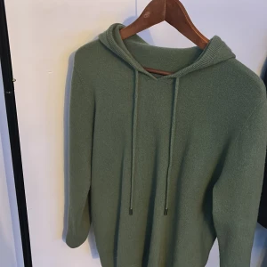 Grön merinoull hoodie - Säljer en grön merinoull hoodie.knappt använd då den är för liten