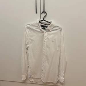 Vit skjorta från Tommy Hilfiger - Klassisk vit skjorta från Tommy Hilfiger med liten broderad logga på bröstet. Fint skick.