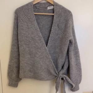 Grå omlottkofta från Only - Mysig grå omlottkofta från Only med knyt i sidan. Storlek S