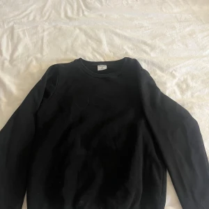 Svart sweatshirt från Stories - En klassisk svart sweatshirt från Stories i storlek XS. Tröjan har rund halsringning, långa ärmar och ribbade muddar vid ärmslut och nederkant. Perfekt basplagg för garderoben och enkel att matcha med allt. Inga hål eller fläckar men nopprig inuti❣️❣️❣️