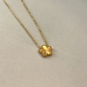 Halsband från Gina Tricot - Elegant halsband i guld med en fyrklöverformad berlock. Kedjan är tunn och smidig, perfekt för att ge en stilren touch till din outfit. Berlocken har fina detaljerade kanter som ger ett exklusivt intryck. Guldpläterad och helt ny ✨ Inköpt för 249kr