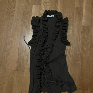 Olivgrön ribbad topp med volang från Zara - Säljer en jättefin topp från zara! Toppen är använd en gång och är i mycket bra skick❤️den är även mycket stretchig!!