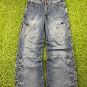 Blå cargopants med vida ben och kardborre - Säljer ett par blå cargopants från cordon med bred passform och unika kardborre-detaljer längs benen. Passar bra för dig som gillar loose fit och funktionella detaljer.