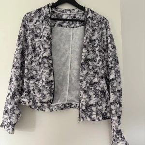 Tunn jacka/kofta med dragkedja  - Tunn jacka/kofta med dragkedja mönstrade blommor på. Väldigt fint skick med innerficka vet ej storlek mellan S-M
