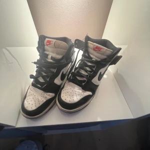 Nike Air Jordans  - Säljer ett par klassiska Nike Air Jordans i svart och vitt med röd Nike-logga på plösen. Skorna har hög modell, snörning. Köpta för 1400kr för 2 år sen men int andvänt på 1 och ett halvt år, de har inga hål o känns som nya. Pris kan diskuteras 
