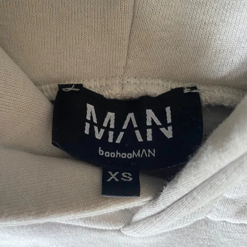 Säljer en stilren vit hoodie från boohooMAN. Den har en klassisk design med en stor ficka framtill och en bekväm huva. Perfekt för en avslappnad look.. Neuletakit & Villapaidat.