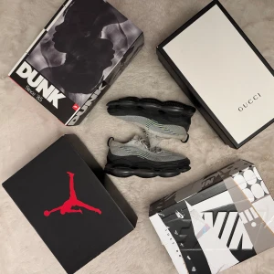 Nike Air Max Scorpion grå sneakers med stickad ovandel - Grå Nike Air Max Scorpion sneakers med stickad ovandel och svarta, tjocka sulor. Skorna har snörning och detaljer i neongult och blått på sidorna. Perfekta för dig som gillar sportig stil och vill ha bekväma skor med modern design.