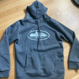 Mörkgrå Cortiez - Säljer en mörkgrå hoodie från Cortiez i storlek M, använd fåtal gånger den är i nyskick. Hör av dig vid frågor 🤩