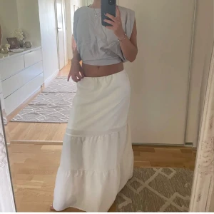 Vit långkjol med volang - Säljer en vit långkjol med volangdetaljer. Kjolen har en luftig och flowy passform, perfekt för varma dagar. HELT NY med prislapp på!! ☀️🌸 XS passar även S! Lånade bilder