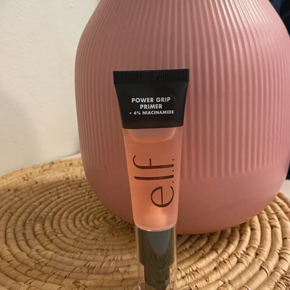 Power Grip Primer från e.l.f. med 4% niacinamide. Kommer i en genomskinlig tub med svart lock och svart etikett. Primern har en lätt rosa ton och är perfekt för att skapa en jämn bas innan smink.. Beauty.