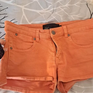 Orange jeansshorts från Zeul Edition - Säljer ett par orange jeansshorts från Zeul Edition. Klassisk femficksmodell med knapp och dragkedja framtill samt bälteshällor. Perfekta för varma dagar och har en snygg, enkel design. Säljer pga. Är lite för stora för mig men jätte bra skick❤️❤️