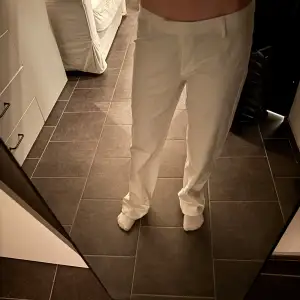Säljer ett par stilrena vita kostymbyxor med normal passform. Byxorna har raka ben, diskreta fickor och klassisk look. Perfekta för dig som vill ha en clean och fräsch stil. Skriv vid funderingar.