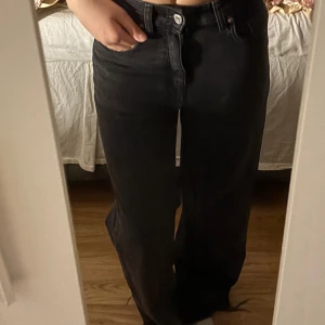 Svarta raka jeans - Säljer ett par svarta jeans med rak passform och hög midja. Jeansen har klassisk femficksdesign och stängs med knapp och dragkedja. Perfekta till vardags för en avslappnad men snygg look.