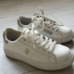 Vita Skor - Säljer ett par vita vårsneakers från Tommy Hilfiger. Prefekta nu till vår&sommar!! Använd endast ett fåtal gånger🥰 org pris. 1500. Pris kan diskuteras vid snabb affär