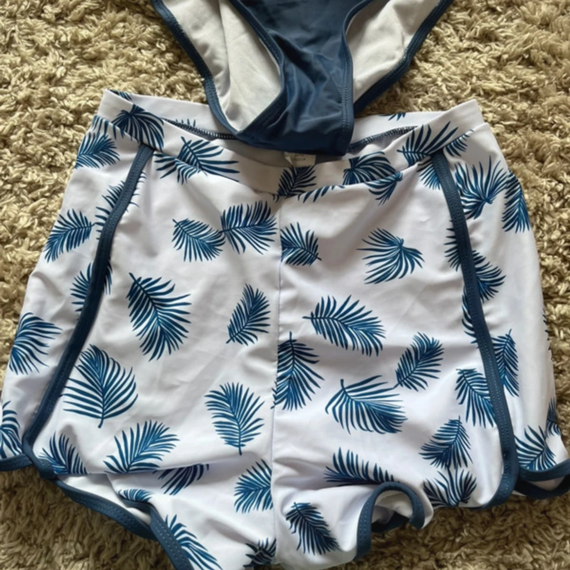 Blå baddräkt och vita badshorts med blått blad-mönster - 1
