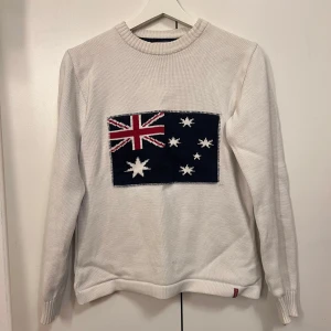 Vit stickad tröja  Holebrook - Vit stickad tröja från Holebrook med en stor australiensisk flagga framtill. Tröjan har rund halsringning (lite sliten, se bilder) och långa ärmar. Högt inköpspris. Storlek M men passar även S,