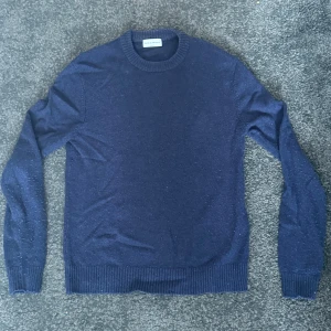 Mörkblå stickad tröja från These Glory Days - Säljer en mörkblå stickad tröja från These Glory Days i storlek medium. Tröjan har rund halsringning och ribbade muddar vid ärmslut och nederkant. Perfekt för kyligare dagar och enkel att matcha med olika outfits.