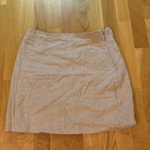 Beige kjol från Gina Tricot - Säljer en beige kjol från Gina Tricot i linne. Kjolen har en rak passform och stängs med dragkedja i sidan. Perfekt att matcha med en enkel topp ☺️