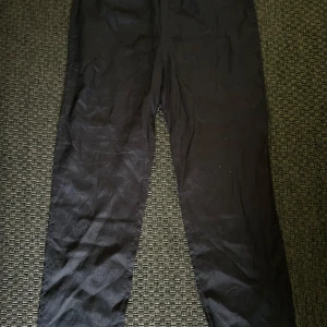 Svarta linnebyxor från H&M - Svarta linnebyxor från H&M med regular fit. Byxorna har resår i midjan och är tillverkade i naturligt linne, vilket gör dem lätta och svala. Perfekta för dig som gillar enkel och stilren design.