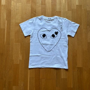 CDG T-shirt - Säljer denna feta CDG play T-shirten i fint skick. Dvs inga typer av defekter. Den passar perfekt för varmare dagar då du kan gå runt med stil! OG tags medföljer. Och så är det bara höra av sig vid intresse ☺️