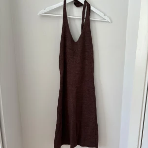 Brun stickad klänning - Säljer en brun stickad klänning med halterneck och knytning i nacken. 