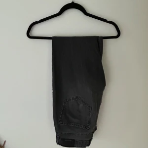 Grå jeansbyxor från Stradivarius - Säljer ett par grå jeansbyxor från Stradivarius. Klassisk femficksmodell med knapp och dragkedja framtill. Snygg tvättad grå färg som passar till mycket. Perfekta för dig som gillar en tidlös stil.
