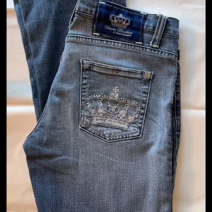 Blå jeansbyxor med strassdetaljer från Victoria Beckham  - Snygga lågmidjade bootcut jeans från Victoria Beckham/rock & republic. Dem är lite upptrampade på baksidan men det är den enda defekten. De är i strl w32 men passar en M/L. Midjemått ca 40-43 och innerbenslängd ca 85💞 Skriv om ni vill ha bilder på!