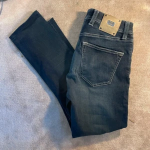 Mörkblå jeans från Tramarossa  - Snygga mörkblå jeans från Tramarossa med  silverfärgad metallpatch bak. Jeansen är i topp skick  ( 9/10 ). Knappt använda utan defekter. Nypris cirka 6000 kr. Hör av er vid frågor eller intresse. ⚡️