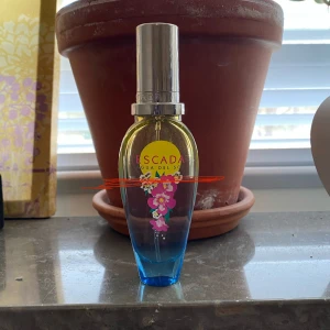 Escada Agua del Sol parfym - Fräsch parfym i en elegant flaska som skiftar från blått till gult med blommigt tryck framtill och silverfärgad kork. Doften är perfekt för dig som gillar fruktiga och blommiga dofter. Det röda strecket visar hur mycket det finns kvar. Skriv om du har frågor o läs gärna min bio innan du köper🫶🏻Jag är öppen för andra prisförslag