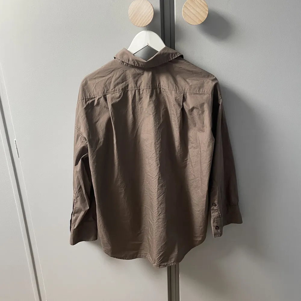 Oanvänd poplinskjorta från Arket i en brun fin färg. I mycket gott skick, endast provad. Nypris 790kr. Skjortor.