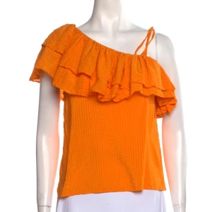 Orange Ganni Blus - Säljer denna superfina oranga Ganni blusen.🧡One shoulder modell som inte säljs längre! Fint skick, inget stt anmärka på. Köpt för ca 1800kr, säljer för 400kr💫92% siden, 8% bomull🧡Storlek 36 (dvs typ S) ☺️PM för frågor, bilder eller bud🙏 Bild 1&2 är lånade