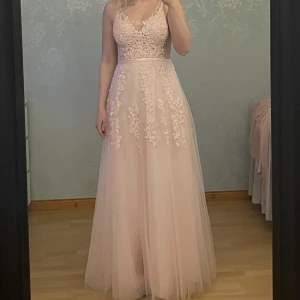 Klänning - En rosa klänning med öppen rygg och dragkedja bak. Använd en gång och har därför blivit smutsig längst ner men det syns inte så mycket när den är på, kom privat för bilder. Klänningen är i storlek S och jag är 169cm.