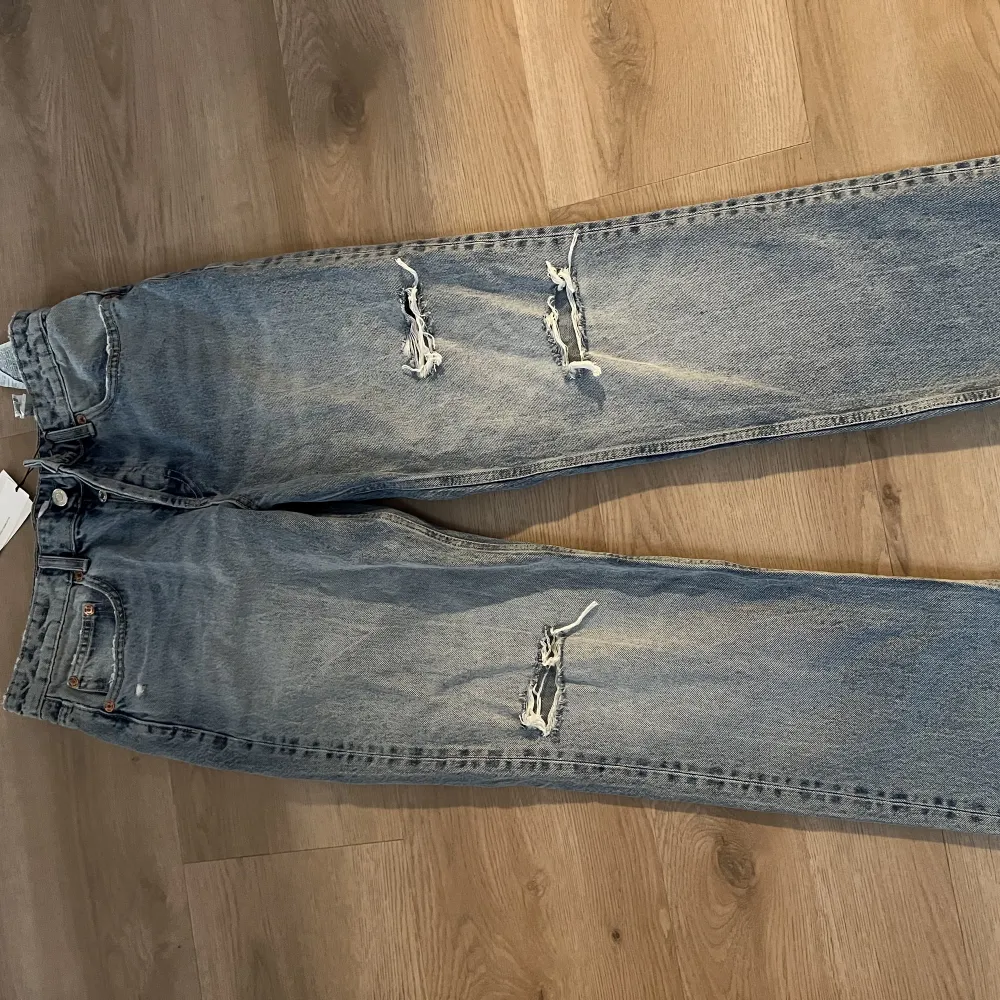 Snygga jeans i straight.  Med en blå tvätt och lite slitningar. Helt nya. Prislapp finns kvar.. Jeans & Byxor.