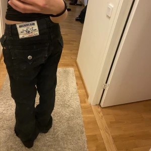 True religion  - Säljer dessa lågmidjade jeans från true religion. Pågrund av ingen användning. Dom är svarta men urtvättade så lite gråa. Materialet är lite mjukare än jeans material vet dock inte vad det heter. Möts bara upp! 