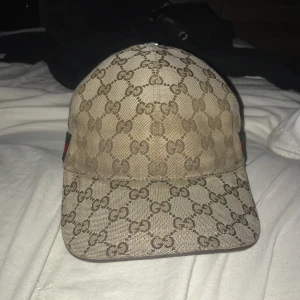 Gucci keps äkta - Hej säljer min Gucci keps den är äkta skriv för mer bilder det enda problemet med kepsen är på toppen så har knappen ramlat kom priv så visar jag.