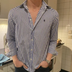 Ralph Lauren Skjorta - Säljer denna färg-glada ralph lauren skjortan. Har haft den några år men den har bara används 2 gånger typ.   Storleken/Passformen balanserar mellan M och S. Natural stretch passform. Modellen är 182 cm och väger 75 kg.