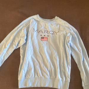 ljusblå Marqy tröja i strl 170/176, köpt på kidsbrandstore. Använd ca 2 gånger och i mycket bra skick.