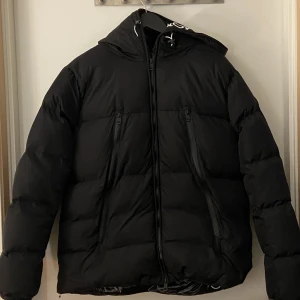 Moncler Jacka - Säljer min Nya moncler jacka eftersom den inte passade mig, tags mm finns den e såklart äkta, kvitto tyvärr förstört i regn Den e matt svart utanpå och innanför jackan är den glansig (se på bild Svart logga Moncler text vid zipen och luva Skriv vid frågor