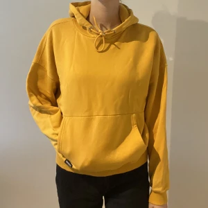 Senapsgul hoodie från DrDenim  - Senapsgul hoodie från DrDenim i storlek M. Köpt på Nelly. Använd fåtal gånger därav nyskick. Säljer pga att den inte kommer till användning.