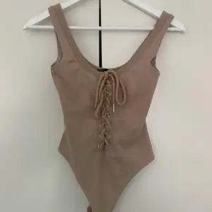 Nude beige Maniere de Voir lace up drawstring dragsko bodysuit. Thong snap close.  Too small 💔. Some loose threads, price reflects this. Moderately used condition . Orig 559 kr. No fading, stains, fuzz, pilling, tears, holes, or rips. Smoke/pet free home.